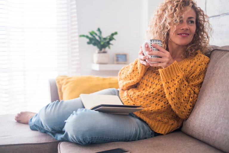 Woman drinking coffee on couch ojqxmOT