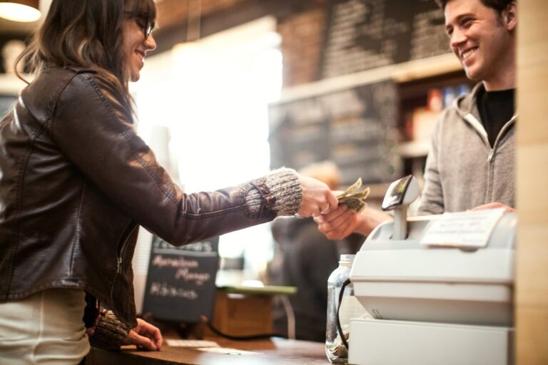 Woman paying for purchase with cash. V7Mjwvr