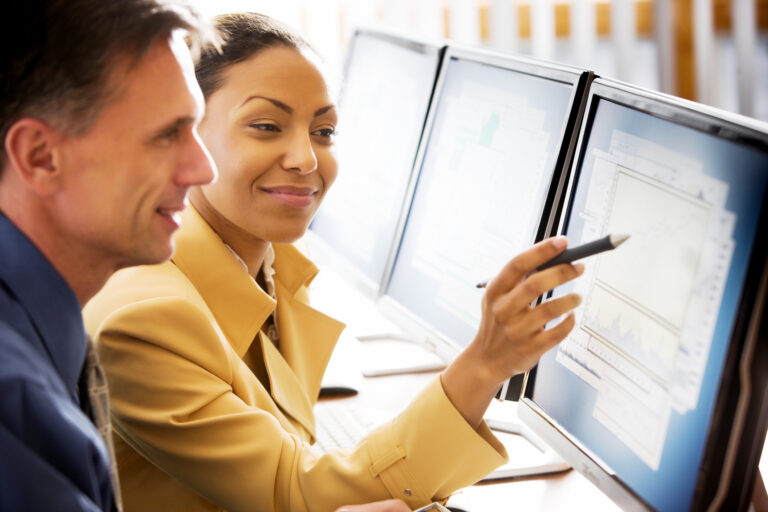 gettyimages woman points at computer with a pen to show something to a colleague