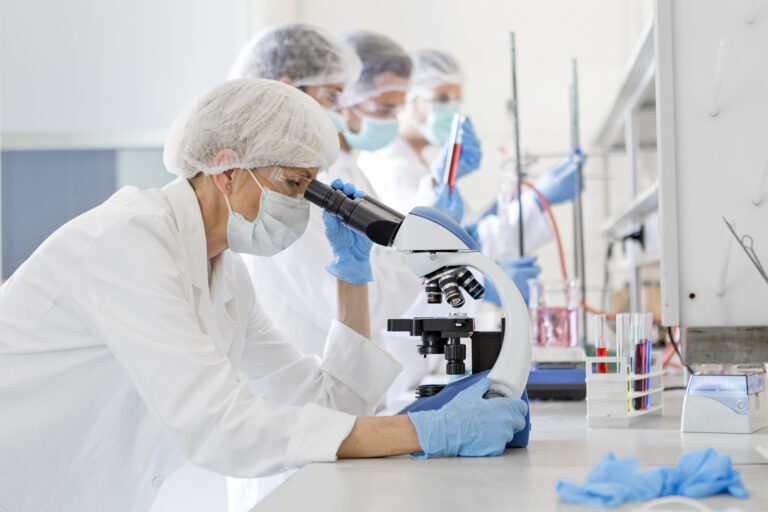 group of scientists with microscopes lab testing