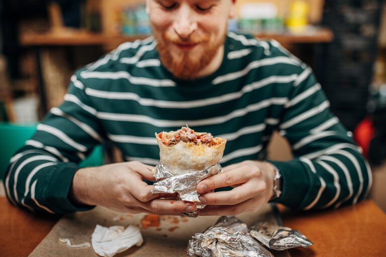 man eat burrito chipotle restaurant