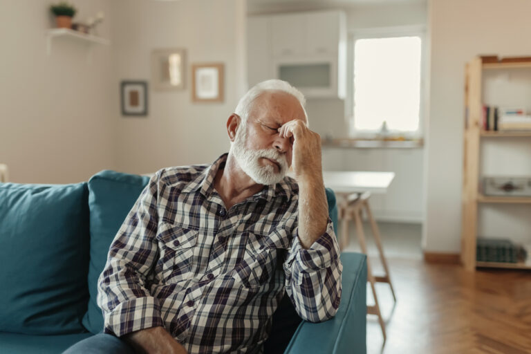 older man couch headache gettyimages 1185122144