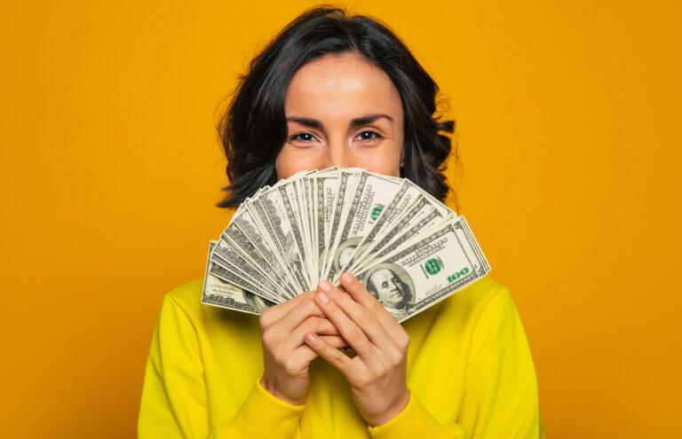 smiling person holds up cash getty 2022