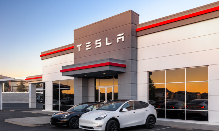 tesla building with tesla logo and two teslas in front