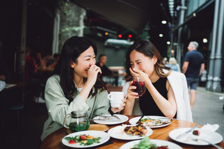 two people enjoying themselves while eating a meal