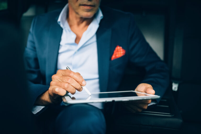 a person in a car signing a digital tablet