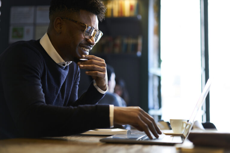 affluent young person smiles reads computer