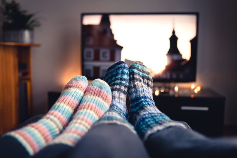 couple wearing wool socks watching television in the winter