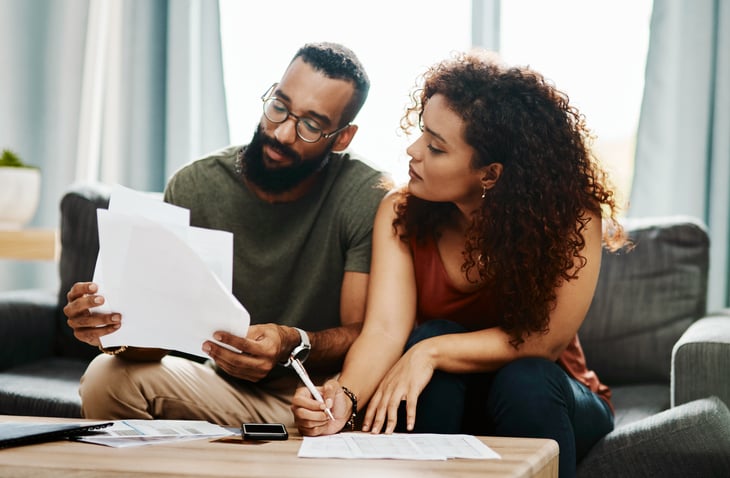 couple with bills signing papers