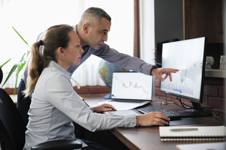 two investors in front of a computer screen