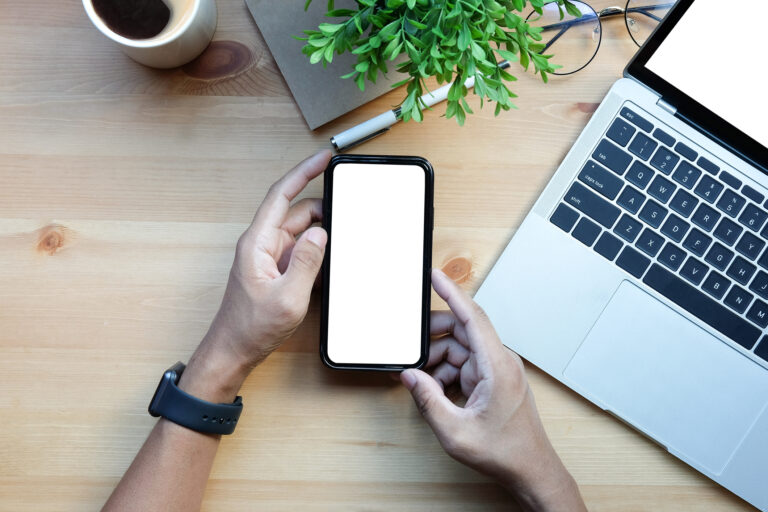 using iphone at desk with apple watch on