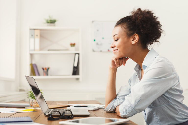 a person sitting at their home office desk using a laptop computer getty