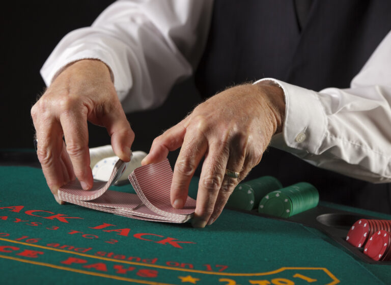 hands of a dealer shuffling cards at a gambling table