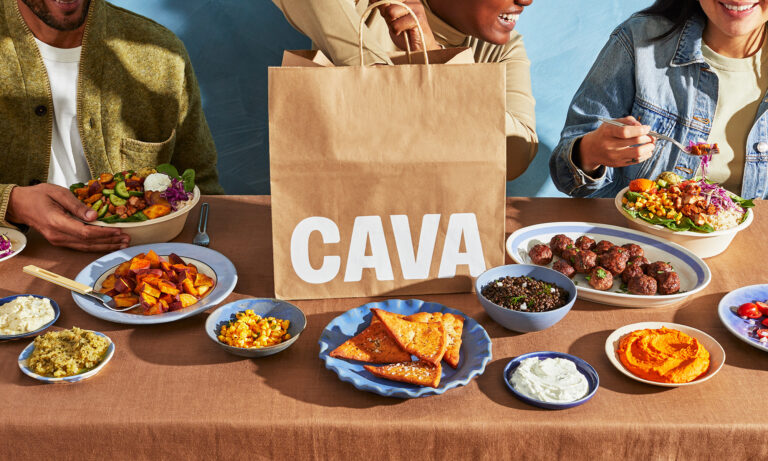 people eating on a table with cava logo in view