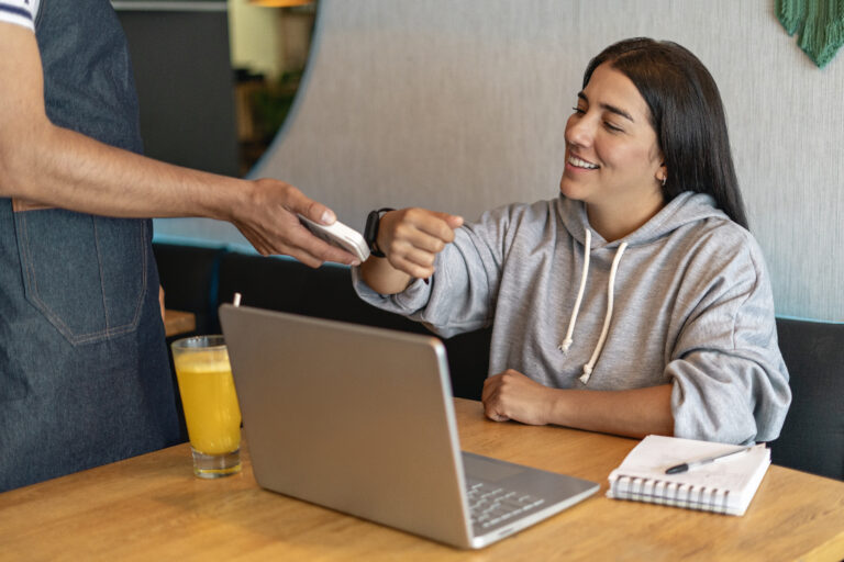 person makes payment using smartwatch getty